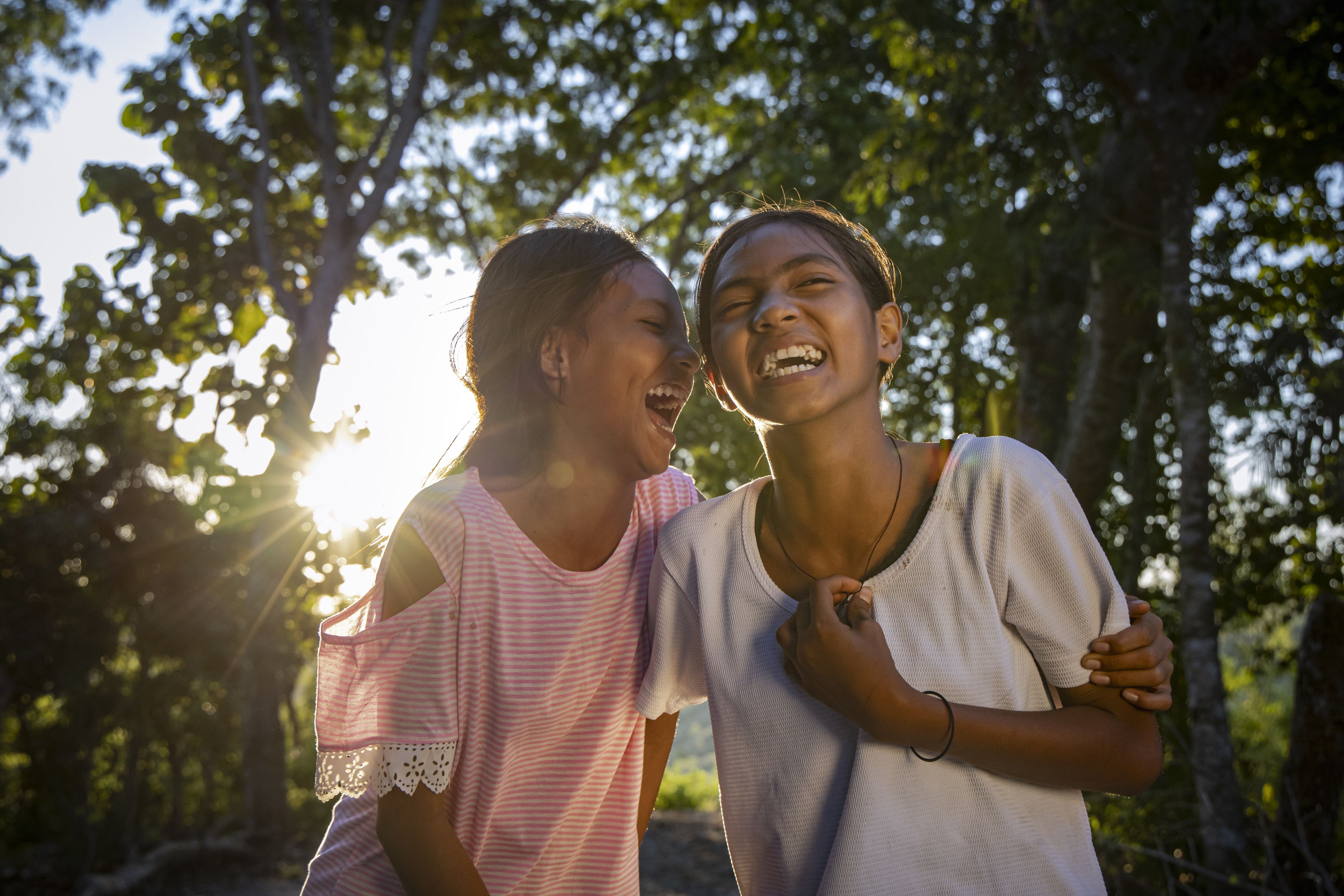 Cousins Atika and Dwi, both 12, laughing in their village in drought-affected East Sumba, Indonesia. 