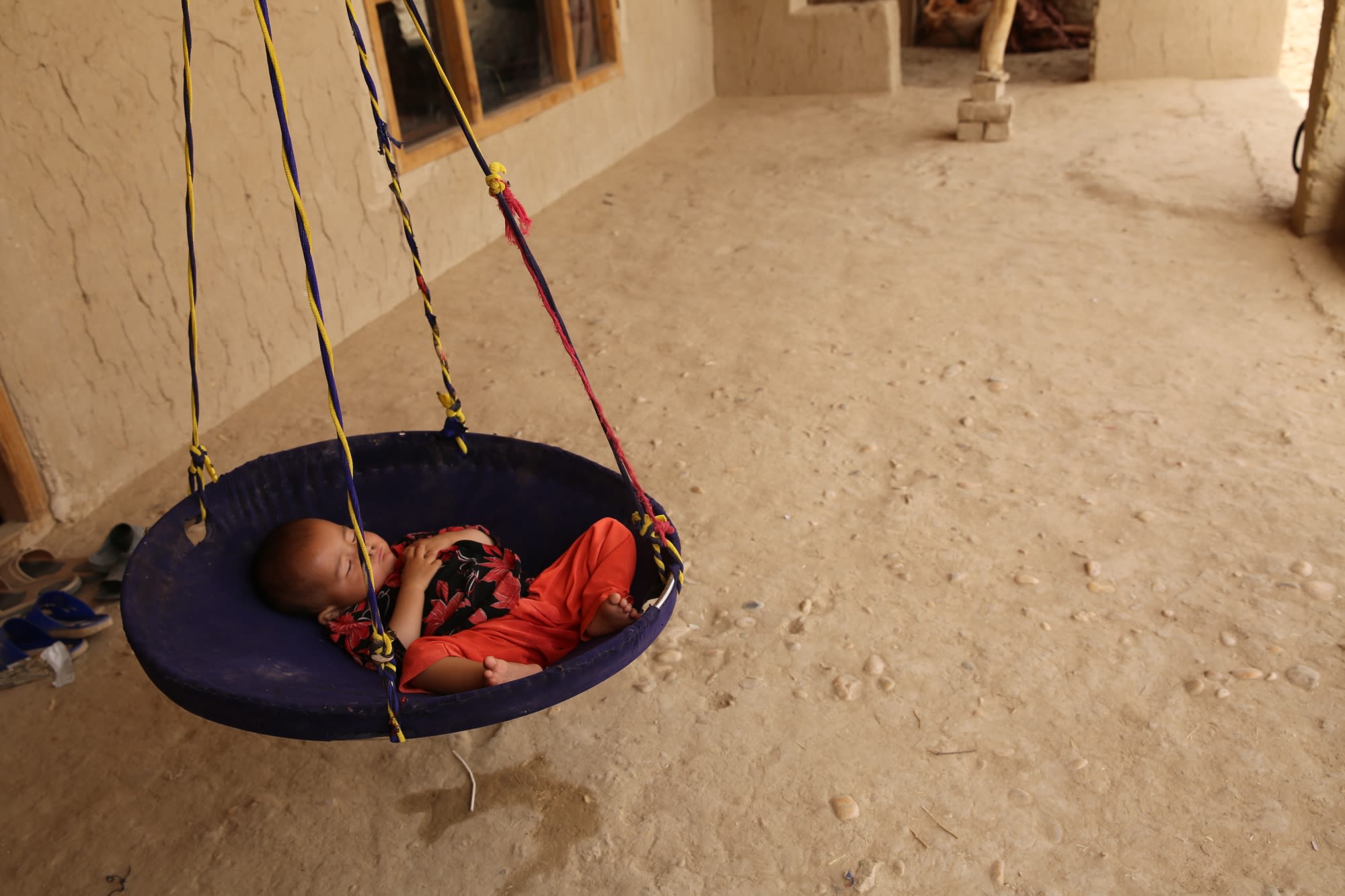 Shayesta* (1), sleeping in a traditional homemade cradle in her family's house. 