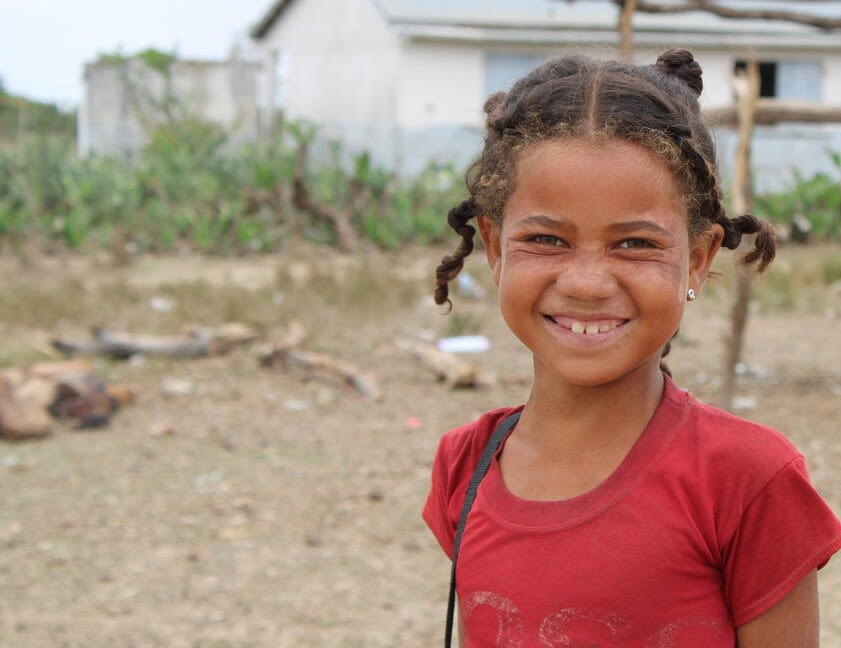 Photo: A portrait of Kazy, 8, smiling in a red T-shirt on her way to school, in the South of Madagascar. Credit: Narindra Rakotonanahary / Save the Children.