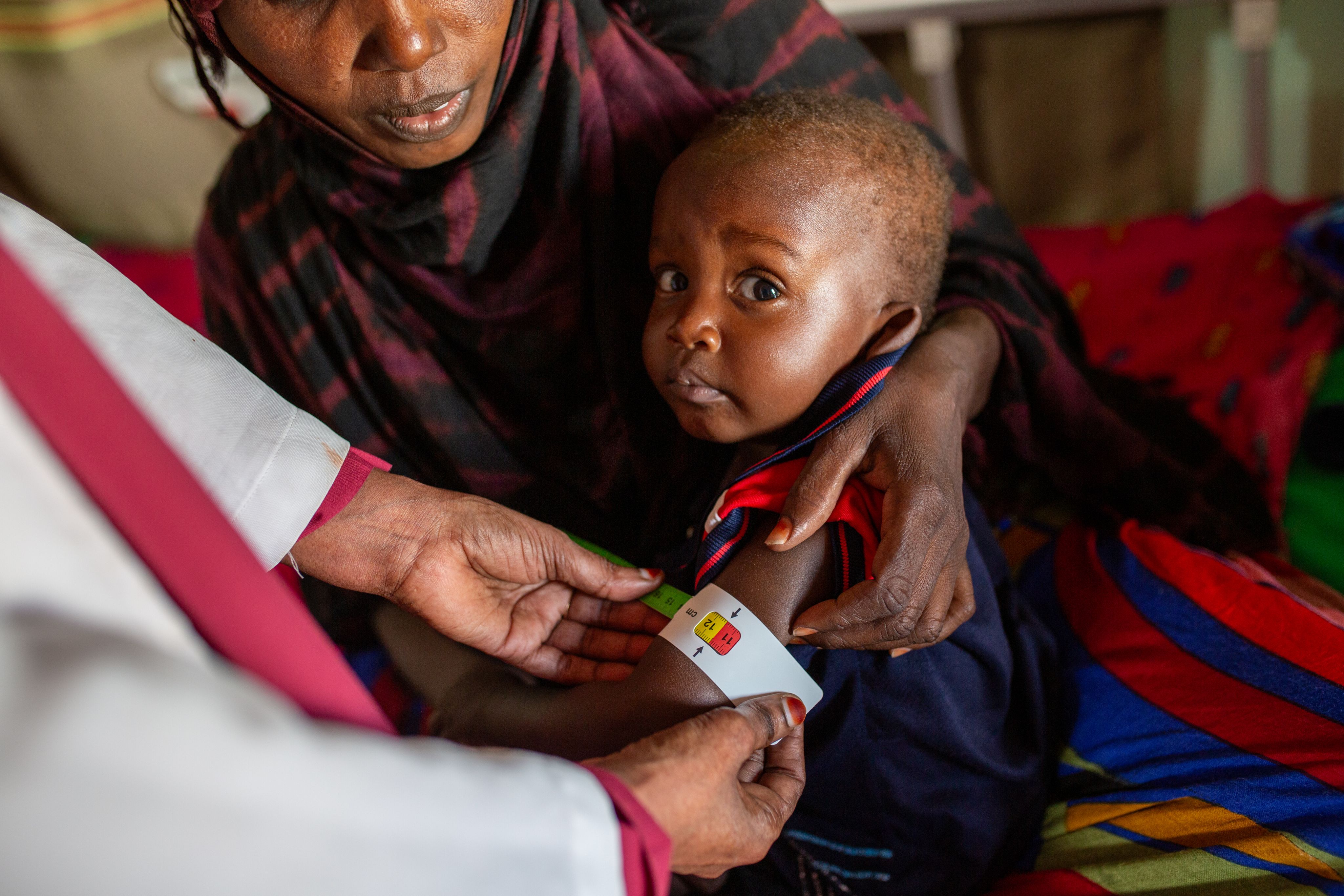 Abdi*, 17 months, is measured for signs of malnutrition with a MUAC band in the Bari region of Somalia.