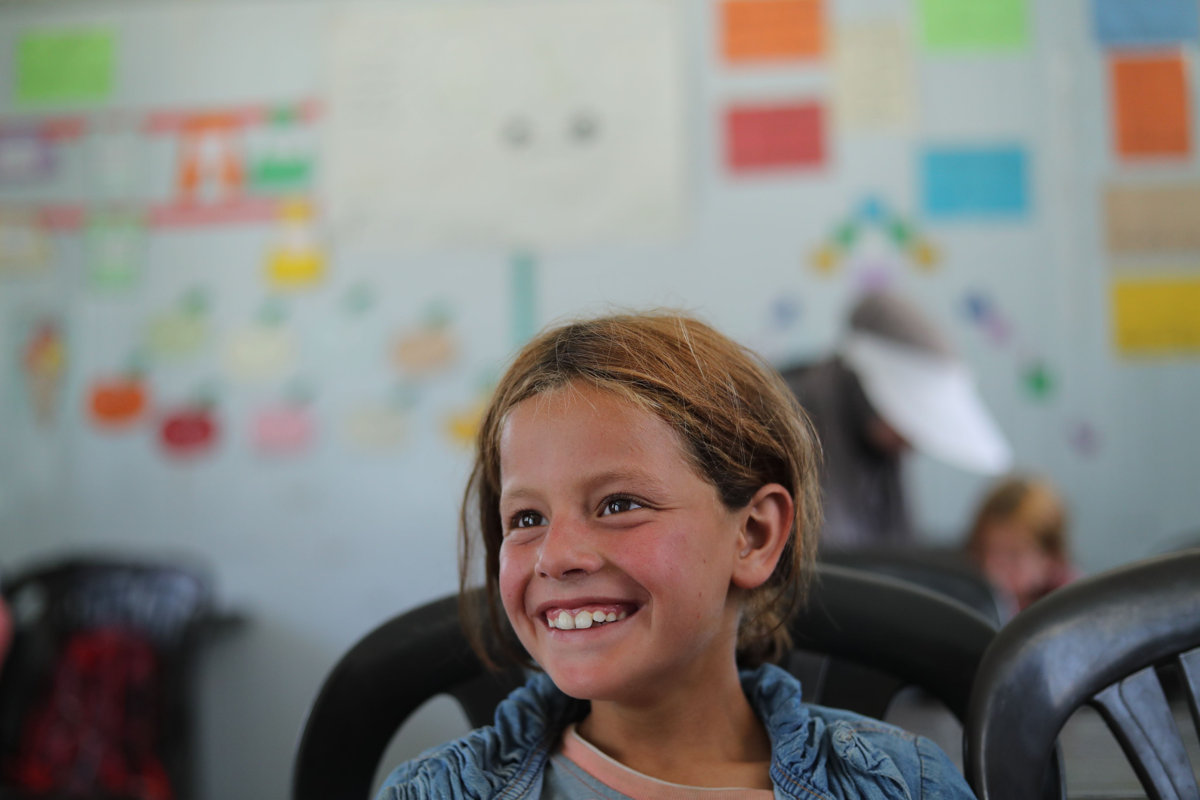 Faiza, 8, smiles during a lesson in her classroom, Syria